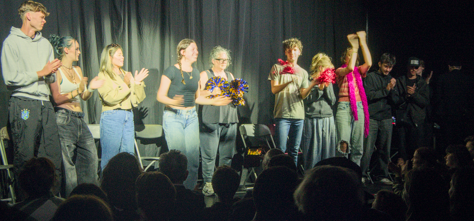 Volunteers and performer applauding at the end of a live stage hypnosis show