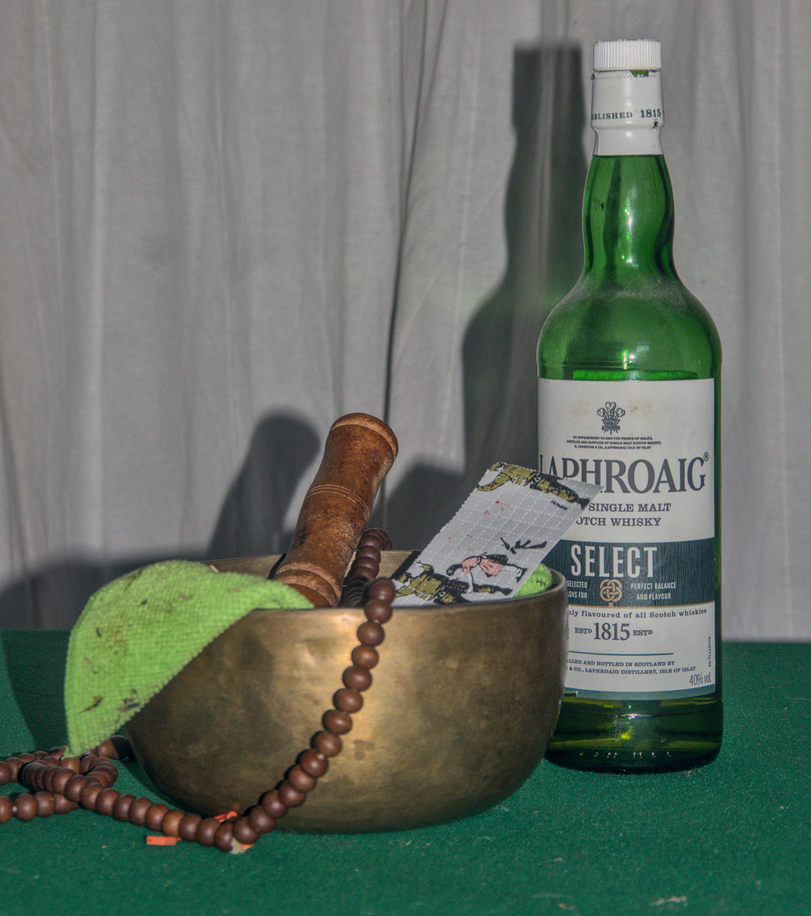 Singing bowl, mala beads, and whisky bottle